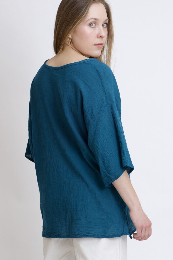 damska bluzka oversize. Modelka w luźnej bawełnianej bluzce w kolorze niebieski petrol