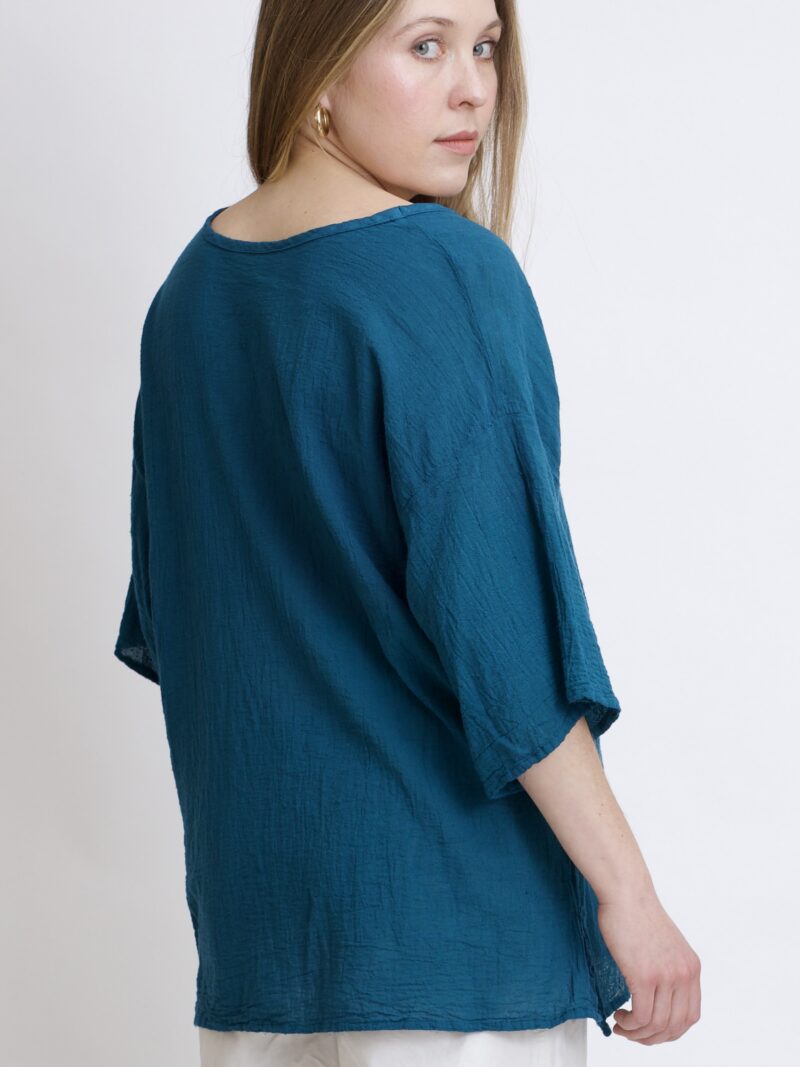 damska bluzka oversize. Modelka w luźnej bawełnianej bluzce w kolorze niebieski petrol