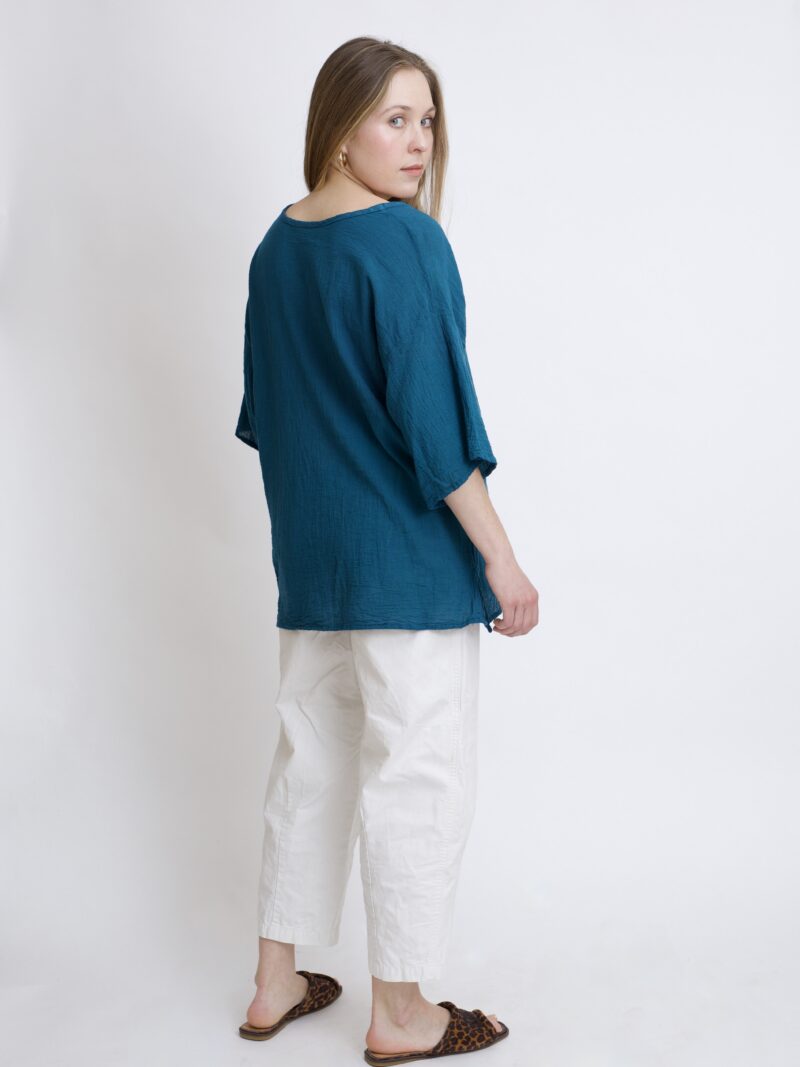damska bluzka oversize. Modelka w luźnej bawełnianej bluzce w kolorze niebieski petrol