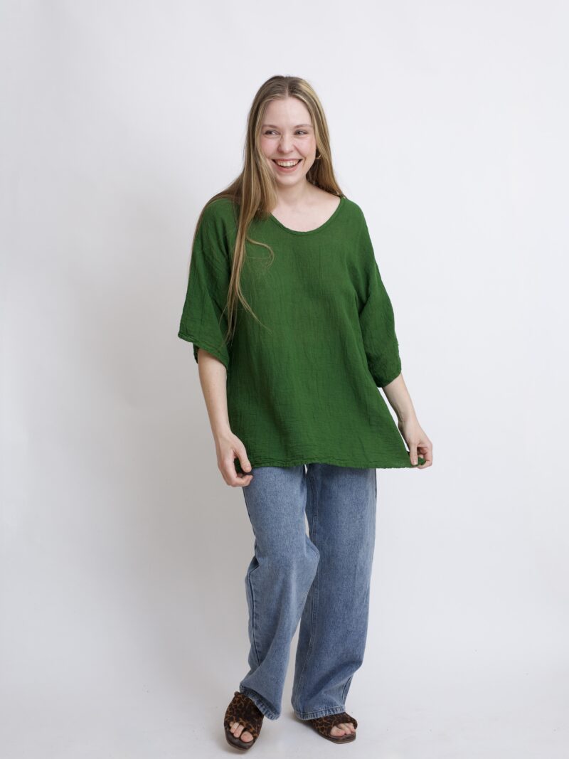 damska bluzka oversize. Modelka w luźnej bawełnianej bluzce w kolorze zielonym