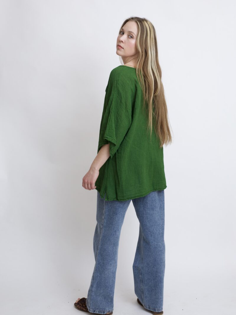 damska bluzka oversize. Modelka w luźnej bawełnianej bluzce w kolorze zielonym