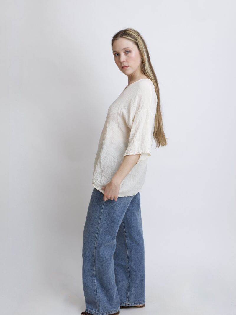 damska bluzka oversize. Modelka w luźnej bawełnianej bluzce w kolorze naturalnej bawełny